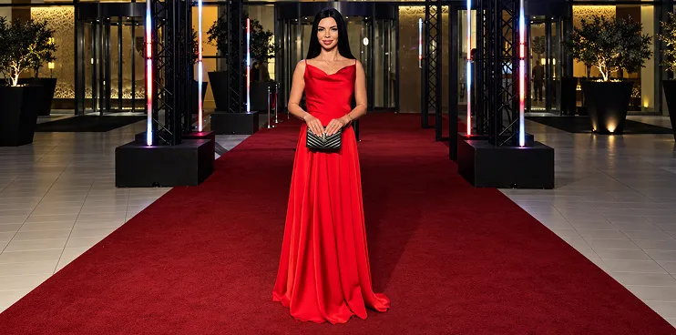 Iryna Ribeiro in a red gown on a red carpet