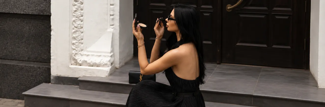 A woman in a long black dress on the steps of a building