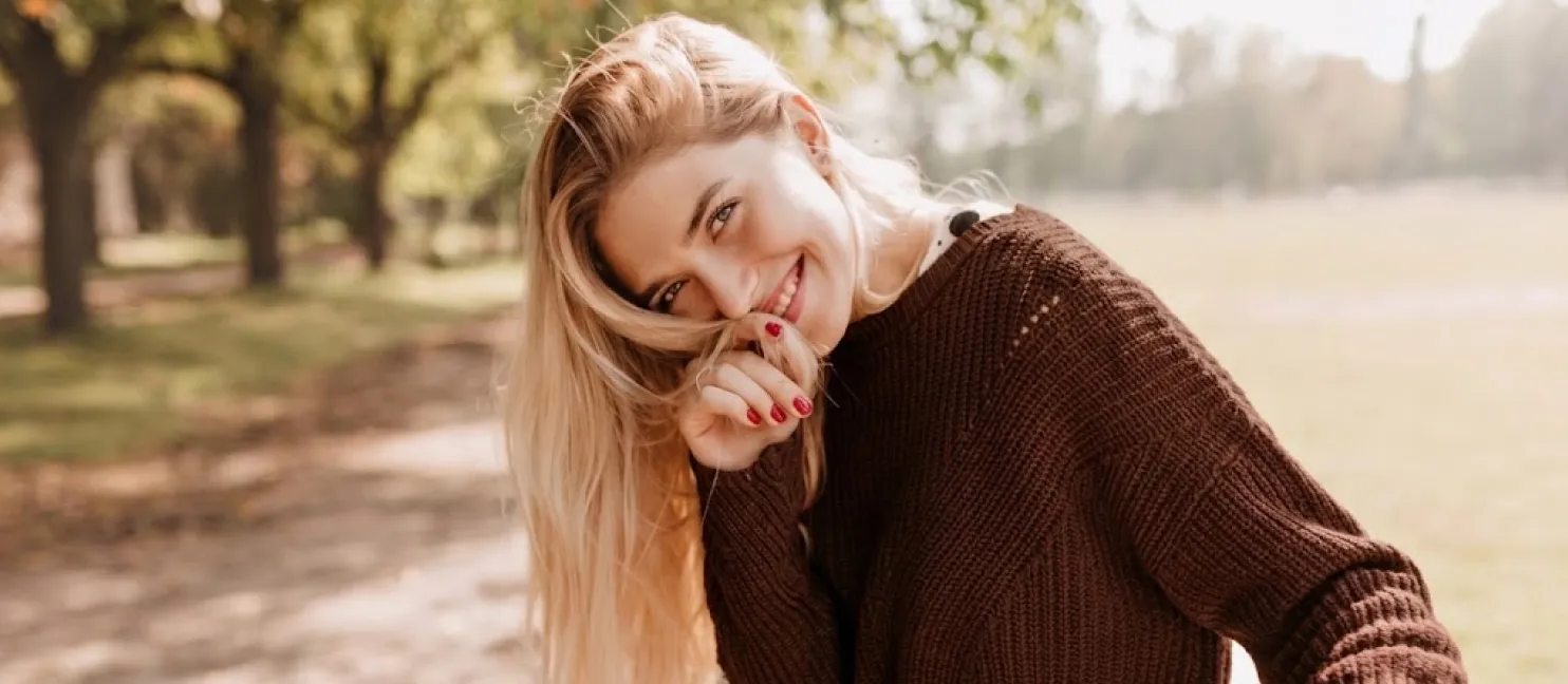 A smiling client in a knitted jumper outdoors