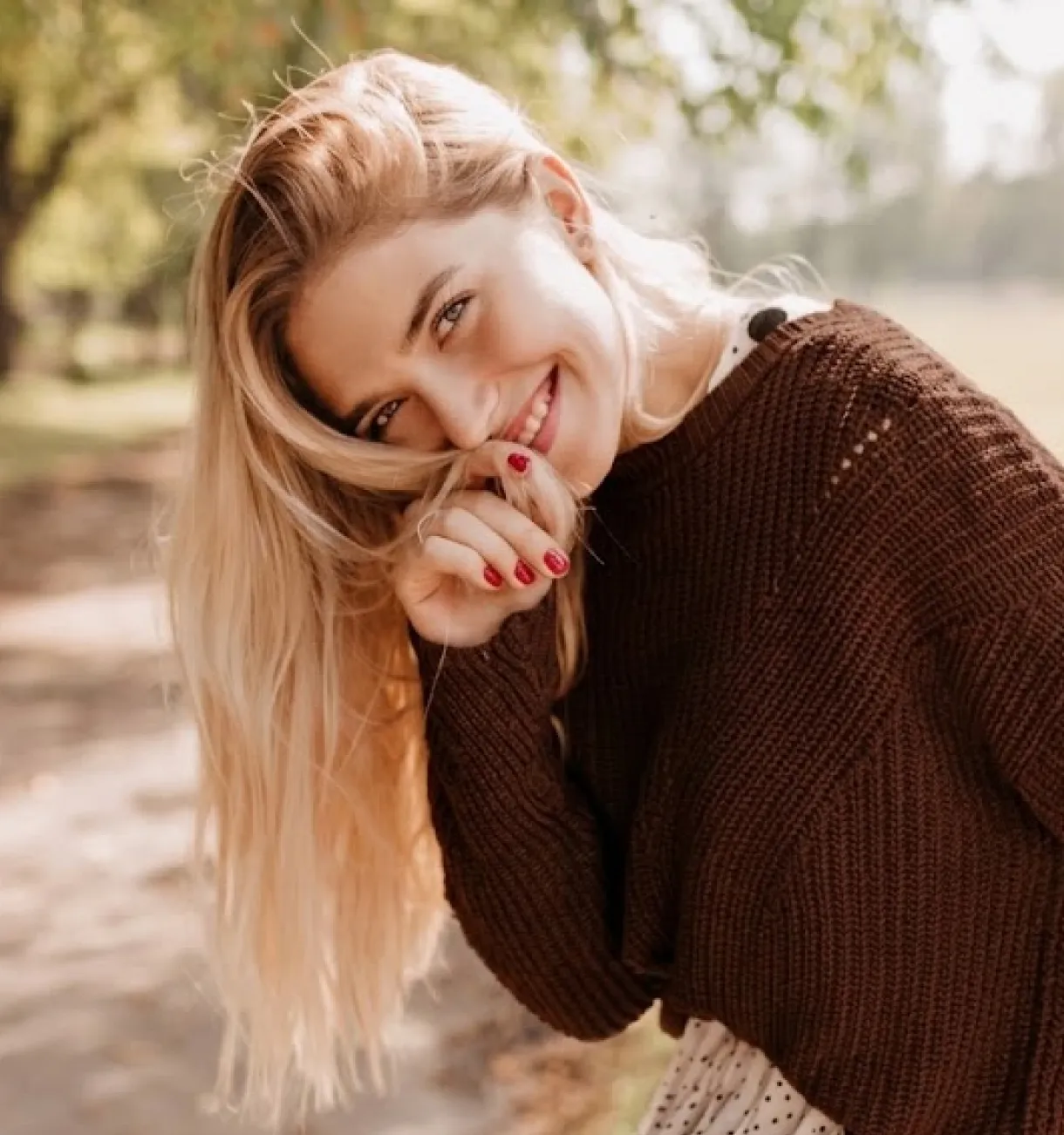 A smiling client in a knitted jumper outdoors