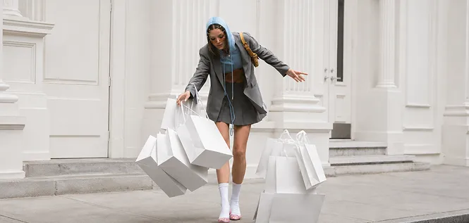 A woman carrying several shopping bags along a city street