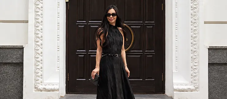 Iryna Ribeiro in a long black dress at the door of a historic building