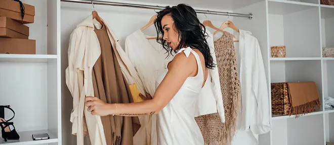 A woman choosing a coat from her wardrobe