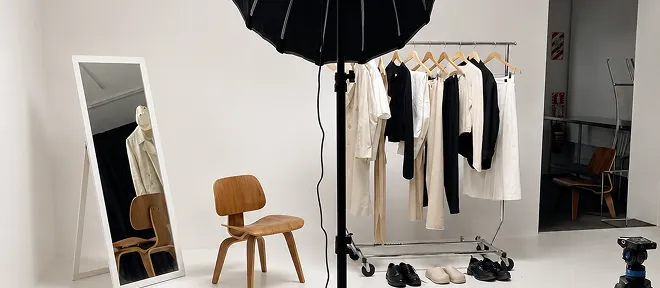 A photo studio with a clothing rail, a mirror and a softbox