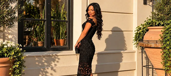 A woman in a black textured dress in the evening light